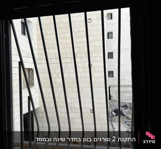 סורגי בטן ממתכת מותקנים בחלון בית